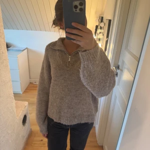 Beige stickad half zip-tröja Vero Moda - Mysig beige stickad tröja från Vero Moda i storlek XS. Tröjan har en relaxed passform, lång ärm och en snygg half zip-dragkedja vid kragen. 