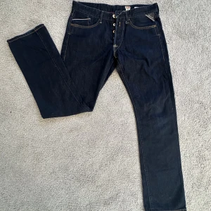 Replay Waitom jeans  - Mörkblå Replay Waitom jeans med klassisk femficksdesign och kontrastsömmar. Jeansen har rak passform och är tillverkade i slitstarkt denim med snygga detaljer som Replay-logga på bakfickan och läderpatch i midjan.