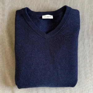 Marinblå kashmirtröja John Henric - Snygg marinblå kashmirtröja från John Henric med v-ringad hals. Tröjan är mjuk och har en klassisk, stilren look som passar perfekt till jeans eller chinos. Ribbstickade muddar vid hals och ärmslut ger en schysst finish.
