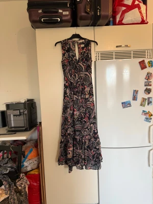 Svart långklänning med blommigt mönster - Säljer en svart långklänning från odd Molly med blommigt mönster i rött, beige och vitt. Klänningen är ärmlös, har v-ringad hals med snörning framtill och volangdetaljer nedtill. Materialet känns lätt och luftigt, perfekt för varma dagar. Storlek 1 som enligt deras storleksguide motsvarar en S. SAMPLE Mycket fint skick, jag hittar inga synliga anmärkningar eller defekter. 