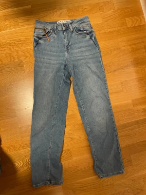raka ljusblå jeans - blåa jeans med rak passform och bruna detaljer från pulz jeans! knappt använda. 