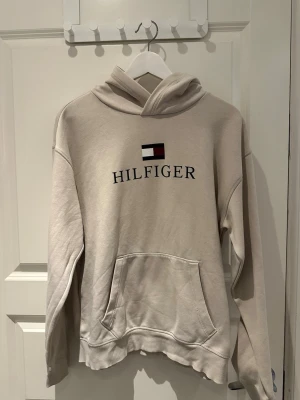 Beige Tommy Hilfiger hoodie - Beige Tommy Hilfiger hoodie i storlek 176. Passar även folk med storlek S