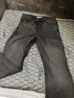 Grå jeans från Gina tricot, storlek 32 - Snygga grå jeans från Perfect Jeans i storlek 32. Klassisk femficksmodell med dragkedja och knapp framtill. Jeansen har en rak passform och är tillverkade i mjukt denimtyg som sitter skönt hela dagen. Perfekt för dig som gillar stilrena och enkla jeans.