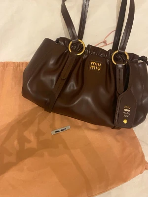 Brun handväska från Miu Miu - Säljer en snygg brun handväska Miu Miu Archive 2006. Köpt second hand och saknar därav äkthetsbevis.