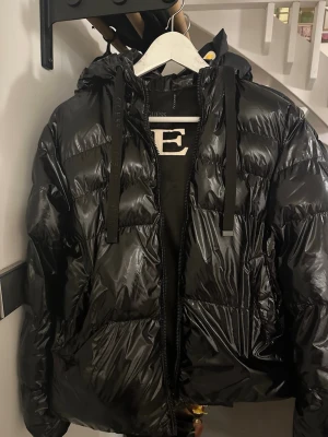 Guess jacka - Glansig pufferjacka från guess. Ett pyttelitet hål längst upp inuti ena fickan, men som inte stör på något sätt och lätt går att laga