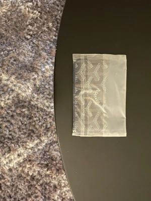 Mörk blå plånbok  - Säljer en brun plånbok ikoniska grafiska mönster i beige och vitt. Plånboken är kompakt och har en stilren design som passar perfekt i fickan eller väskan. Materialet är skinn och den har en lyxig känsla.