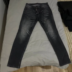Svarta  jeans med tvättad look dsq - Snygga svarta jeans med tvättad och sliten effekt. Perfekta för dig som gillar en modern och stilren vibe.