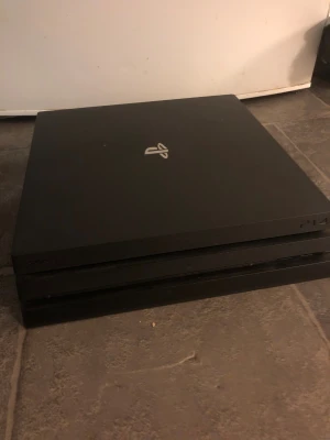 PlayStation 4 Pro - Sony PlayStation 4 Pro i svart, i gott skick. Konsolen har en stilren design och är perfekt för gaming i 4K. Mindre tecken på normalt bruk, inga synliga större repor eller skador. Perfekt för dig som vill ha kraftfull prestanda och stort spelutbud.