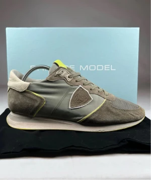 Philippe Model TRPX - Snygga sneakers från Philippe Model i grå och beige toner med inslag av limegul på plösen och sula. Ovandel i mocka, mesh och syntet med snörning och rund tå. Ikonisk sköldlogga på sidan och kontrastdetaljer som ger en cool vibe. Detta är en förbeställning, snabbast frakt 3 dagar. Pris kan diskuteras.