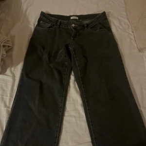 Gråa ultra low wide jeans - Säljer ett par gråa jeans Gina tricot i storlek 40. Modellen har en rak och wide passform med klassisk femficksdesign och knappstängning. Ultra low wide