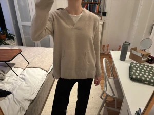 Beige hoodie från Soft Goat i kashmir - Mysig beige hoodie från Soft Goat i mjuk kashmir. Tröjan har huva, v-ringad hals och en stor magficka framtill. Passformen är loose och ärmarna är långärmade. Perfekt för chill dagar och när du vill ha det extra bekvämt. Står storlek XL men jag brukar ha S💕💕