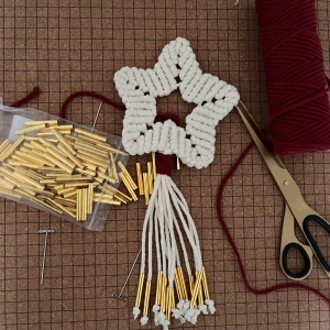 Makraméstjärna med vinrött och gulddetaljer - Denna lilla stjärnan har jag knutit med hand. Den har guldfärgade detaljer och vinrött band som ger en mysig julkänsla 🎄❤️