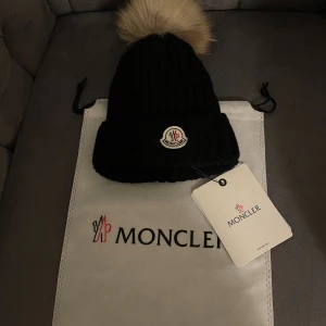  Moncler mössa tjej  - Svart  mössa från Moncler . och levereras med originalpåse och tag QR kod finns och går att skanna, original påse tillkommer 