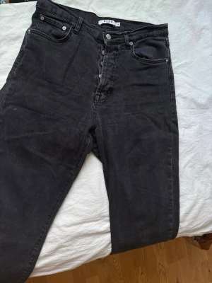 Svarta raka jeans med knappar – Mid waist - Snygga svarta jeans med rak passform och mid waist. Istället för dragkedja har de flera knappar. Perfekta för både vardag och fest. Bekväma och stilrena!  Storlek 40, och true to size. Mer oversized för någon som är 36-38strl 