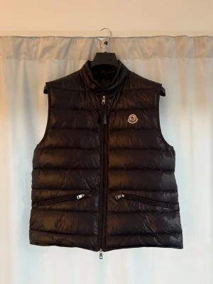 Moncler Gui väst  - Säljer nu min Moncler gui väst. Den är i nyskick och allt finns kvar såsom kvitto dust bag etc. Den köptes på monclers officiella sida. Nypris är 9k och jag släpper den för 3249 ett bra pris enligt mig för vad du får. Priset ej hugget i sten så skriv och lägg bud. Storleken är 4 motsvarar L. Kom Dm för mer information!