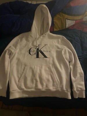 Calvin Klein hoodie  - Vit Calvin Klein hoodie i storlek M, den är stor i storleken så jag skulle säga att den passar L mer än M. Inga skador osv, den har bara blivit stor i storleken annars är den i ett mycket bra skick. Hör av dig vid frågor😁