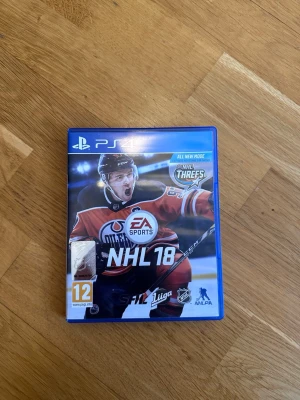 NHL 18 PS4 - NHL 18 till PlayStation 4 i fint skick. Upplev autentisk NHL-action med nya 3-mot-3-läget NHL Threes, kreativa attacker och expansion draft. Fodral och skiva är i bra skick, inga synliga repor eller skador.
