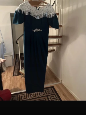 Elegant Teal Maxi Dress with Silver Beaded Fringe - Beautiful long maxi dress from SHEIN in a deep teal / dark green color. Features an elegant silver beaded neckline with fringe details, short sleeves, and a delicate crystal embellishment at the waist that gives a flattering silhouette. Perfect for formal events, evening parties, weddings, or special occasions. Brand: SHEIN Size: L (EU 40/42, US 8/10) Length: Maxi / floor-length Color: Teal / dark green Condition: Very good Made in China Feel free to message me if you want more photos or measure