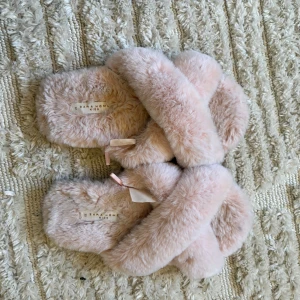 Rosa fluffiga sandaler Zara Home Kids - Supermysiga sandaler från Zara Home Kids i ljusrosa färg med korsade band och fluffig pälsimitation. Sulan är ljusrosa med hexagonmönster och sandalerna har öppen tå. Perfekta för chill hemma eller när du vill ha extra cozy vibes.
