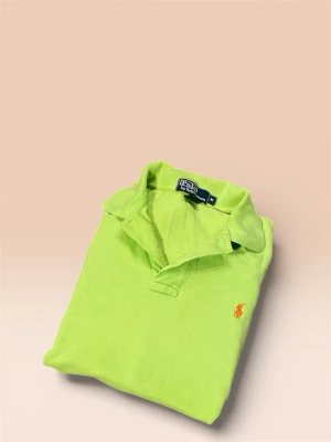 Grön pikétröja från Ralph Lauren - Säljer en fräsch grön pikétröja från Polo Ralph Lauren i storlek M. Tröjan har klassisk krage, korta ärmar och orange broderad logga på bröstet. Materialet är 100% bomull och modellen är normal passform. Perfekt för dig som gillar färg och stil!
