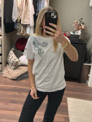 Vit t-shirt med paljettorm - Cool vit t-shirt från REPLAY med en stor glittrig paljettorm! Använd en gång och är i mycket bra skick!!