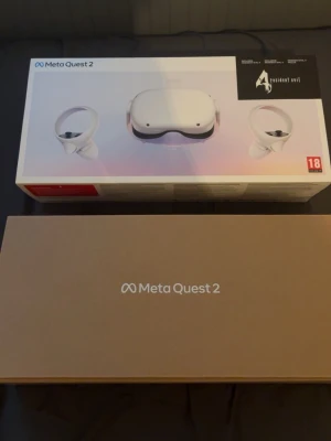 Meta Quest 2 - Meta Quest 2 VR-headset med två handkontroller, komplett i originalförpackning. Produkten ser ut att vara i mycket gott skick utan synligt slitage. Perfekt för uppslukande VR-upplevelser och spel. Resident Evil ingår enligt förpackningen.