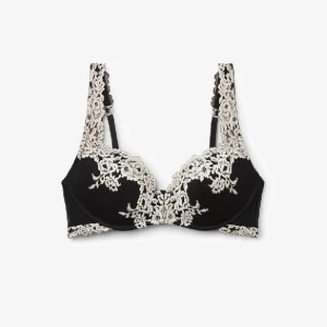 Svart Intimissimi bh med spetsdetaljer - Supersnygg svart Intimissimi bh med krämvit spets som ger en lyxig och romantisk vibe. Den har formade kupor och breda axelband med spets, perfekt för att lyfta din outfit. Spetsen har ett blommigt mönster som gör bhn extra unik och feminin.