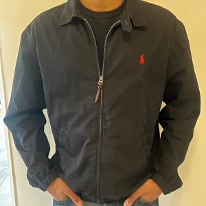 Svart bomberjacka från Polo Ralph Lauren - Jag säljer denna otroligt fräscha och stiliga harrington jacka ifrån Polo Ralphlauren. Den är i storlek M och passar helt perfekt nu till hösten. Nypris ligger på ungefär 2500–3000 kr. Jackan är i topp skick och har tagits väl hand om. Hör av er vid funderingar eller diskussion gällande priset!!