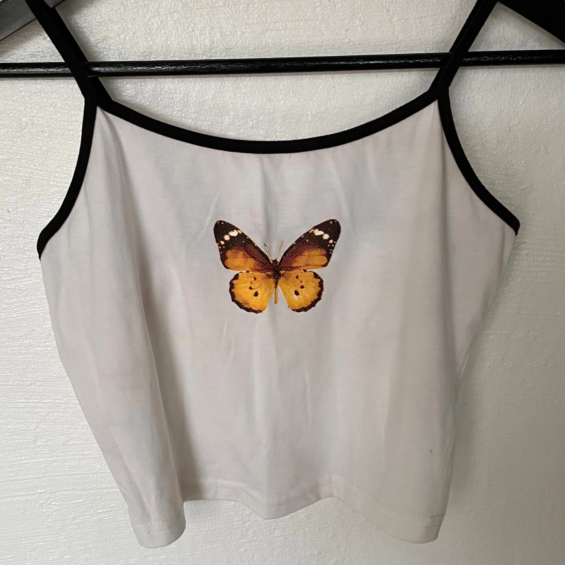 Vit croppad linnetopp med fjäril