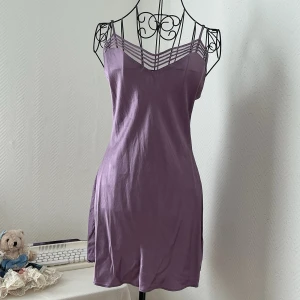 Silkesklänning från Victoria’s Secret - Supersnygg lila kortklänning i 100% silk med tunna axelband och meshdetaljer vid v-ringningen. Storlek S, passar bäst 32-34. Dockan har storlek 34.