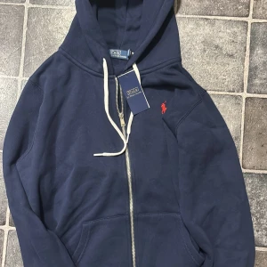 Marinblå hoodie från Polo Ralph Lauren - Säljer nu denna feta hoodie från Ralph lauren aldrig andvänd så helt ny skick då den var för liten kvitto finns pris går att diskutera hör gärna av dig om du undrar något🙂