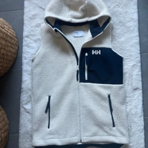 Helly Hansen fleece väst - Säljer en super snygg helly hansen fleece väst. Den är i mycket bra skick. Använts ett par gånger. Inga defekter. Varm och har innerfickor. Strl 16. sitter som en xs.  Fraktar samma dag!
