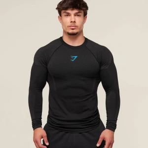  Gymshark Onyx v5 Black/gray blue logo longsleeve - Svart långärmad seamless träningströja från Gymshark med blå logga på bröstet. Tight passform med ventilerande meshpaneler på axlar och armar. Perfekt för gymmet eller annan träning. Materialet är syntet och polyester för maximal komfort och rörelsefrihet.