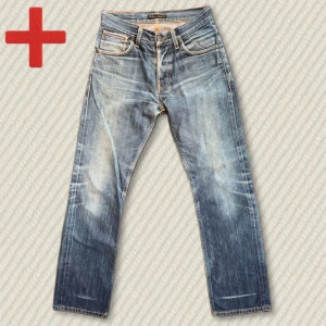 Nudie Jeans Average Joe Dry Red Selvedge - Riktigt snygga Nudie Average Joe Dry Red Selvedge med grym fade och whiskers. Storlek 29/32. Lagade efter en blowout men i övrigt i mycket bra skick. Mått: Midja – 38,5 cm, Innersöm – 76,5 cm, Yttersöm – 101 cm, Lår – 27 cm, Benöppning – 20 cm. Skriv gärna vid frågor!