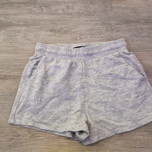 Grå mjuka shorts från Lager 157 - Säljer ett par ljusgrå shorts från 157 i storlek S. De har elastisk midja och är gjorda i mjuk bomull, perfekta för chill dagar. Klassisk design med två sidofickor och avslappnad passform. Enkla att matcha med t-shirt eller hoodie.