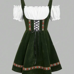 Oktoberfest klänning  - Supersöt grön kortklänning från Bettina med vit puffärm och snörning framtill. Klänningen har blommiga broderier längs midjan och nederkanten, samt omlottkänsla vid bysten. Materialet är mjukt och har en sammetliknande finish. Perfekt för dig som gillar traditionell stil med en modern twist.