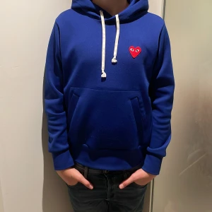 Blå hoodie Comme des Garçons Play  - Tja, säljer den sjukt feta cdg hoodien nu för endast 599! Kostar 2399 från butik. Inga defekter eller något. Jätte fräsch och snygg hoodie. Det står storlek L men passar XS.(163-170cm). Modellen på bilden är 171cm. Hör av er vid funderingar!😊🙌