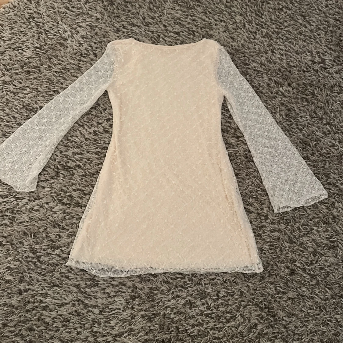 Kort spetsklänning med vida ärmar