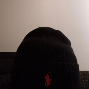 Svart stickad mössa från Polo Ralph Lauren - Säljer nu mera mina Polo Ralph Lauren mössa. Säljer den för att jag inte passar i mössa. Hör av er vid funderingar. Priset ej hugget I sten.