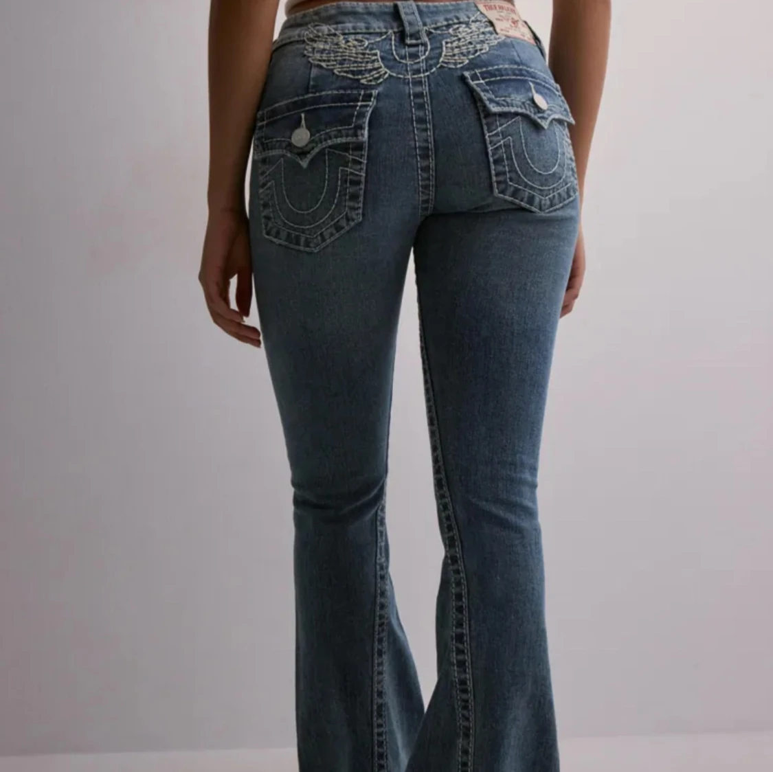 Blå bootcut jeans med broderade fickor