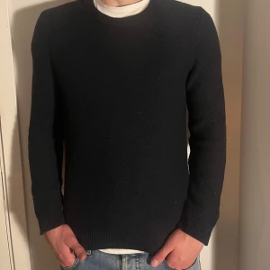 Svart tröja från Shore Leave - Säljer en stilren svart tröja från Shore Leave för Urban Outfitters. Den är i bra skick och perfekt för både höst och vinter. Tröjan har en klassisk design med långa ärmar och är gjord i ett mjukt material som håller dig varm. Passar perfekt till jeans för en avslappnad look.