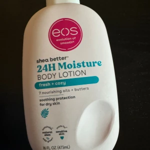 EOS 24H Moisture Body Lotion - Fräsch och mysig body lotion från EOS med sheasmör, 7 vårdande oljor och butters. Passar känslig hud och ger skydd mot torrhet. Flaskan är vit med rosa och turkosa detaljer, innehåller 473 ml.