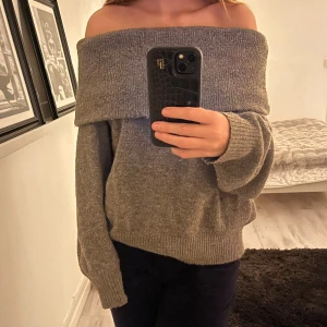Brun/grå offshoulder stickad tröja - Säljer denna mysiga brun/gråa stickade tröja med bred offshoulder krage och långa ärmar. Tröjan är från HM men tror inte den finns kvar att köpa. 🫶🏻