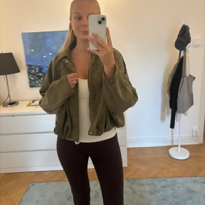 Olivgrön mocka bomberjacka från Zara - Säljer denna trendiga super snygga olivgrön bomberjackan från Zara i mjuk mocka. Jackan har loose passform, dragkedja framtill och krage. Prislapp kvar och papper runt om dragkedjan.🩷💚