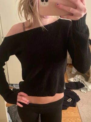 Svart off shoulder stickad tröja - Trendig svart stickad tröja med off shoulder-design! Sitter as nice men kommer inte till användning längre tyvärr☺️Osäker på exakta storlek men skulle säga ca S