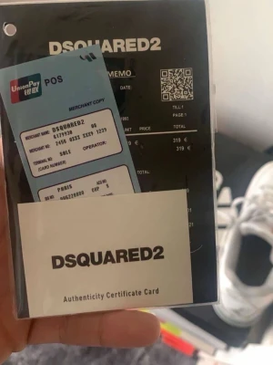 Svarta Dsquared2 jeans med slitningar - Säljer ett par svarta jeans från Dsquared2 med coola slitningar och färgstänk för en edgy look. Jeansen har en rak passform och är tillverkade i bomull med klassisk femficksdesign. Perfekta för dig som vill sticka ut med en streetwear vibe. Dem passar mig bra och är 185cm och 67kg