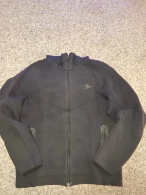 Svart Nike hoodie med dragkedja ”säljer endast på vinted‼️⚠️” - Svart hoodie från Nike med hel dragkedja framtill och två fickor med dragkedja. Klassisk design med diskret Nike-logga på bröstet och huva. Tillverkad i mjukt och bekvämt material, perfekt för en avslappnad stil.