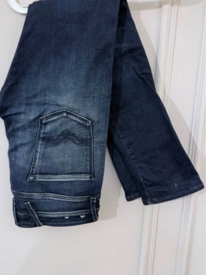 Mörkblåa Replay Anbass - Skitsnygga Replay Anbass jeans. Clean look med fin fading och snygga slitningar som ger jeansen karaktär. Klassisk och tidlös modell som funkar till det mesta. I utmärkt skick. Det står 33 men jeansen passar även bra till W34. Har ni fler frågor eller funderingar är det bara att höra av sig!