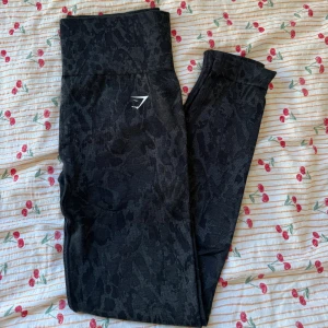 Svarta leopardmönstrade leggings - Gymshark - Snygga svarta leggings från Gymshark med diskret leopardmönster och hög midja. Stretchigt material som sitter tight och formar sig efter kroppen🖤⭐️