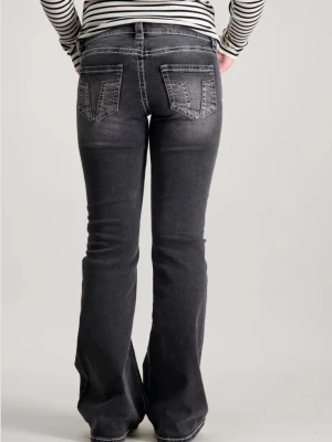 Bootcut svarta jeans med slitningar - Snygga svarta bootcut jeans med slitna detaljer och markerade sömmar. Jeansen har klassiska fem fickor och en lätt tvättad look som ger en cool vibe. Perfekta för dig som vill ha en avslappnad men trendig stil. Några diamanter saknas💞